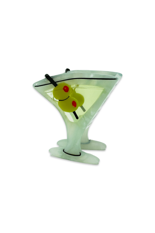 Glass martini glass with a olive and cherry on a white background