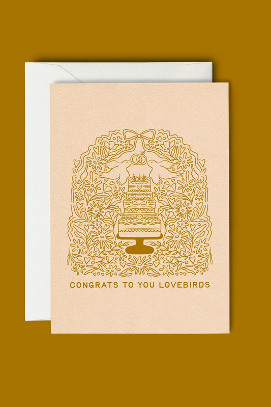 Beige card with gold cake illustration and text on a mustard yellow background